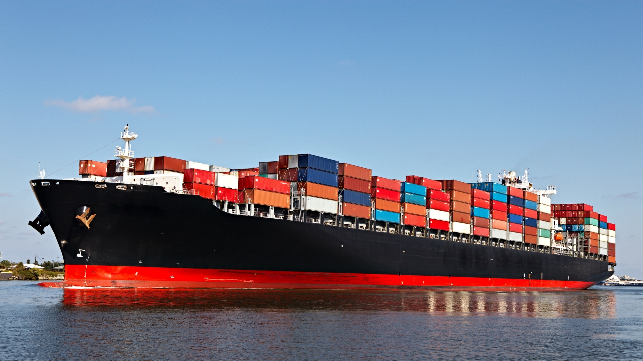 Cargo Ship with stacks of containers arriving at a port of call