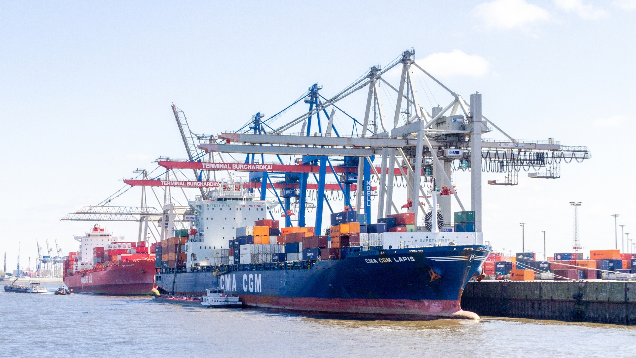 Cargo ship docking at port with cranes