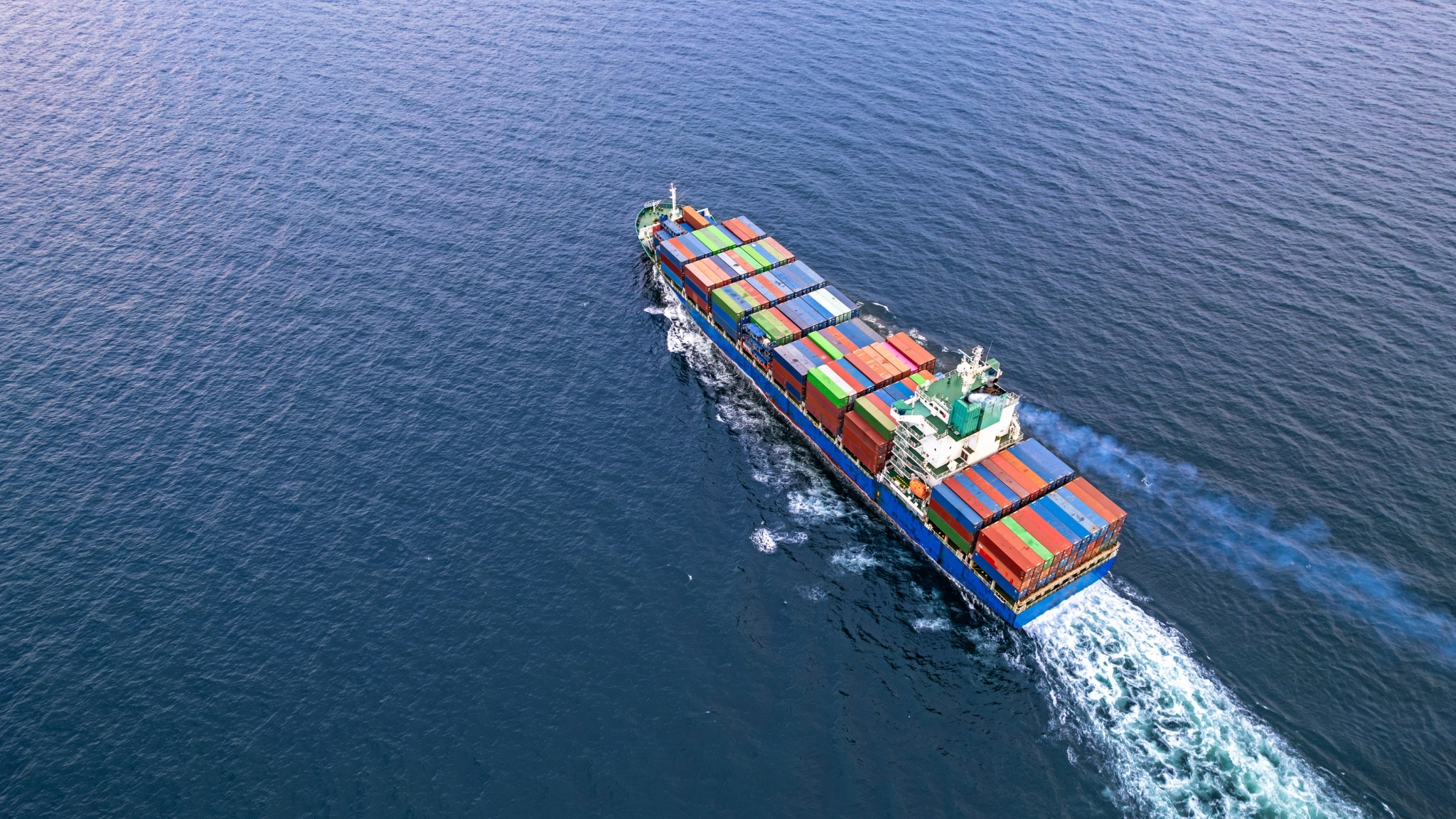 Cargo ship with containers sailing acress the open seas