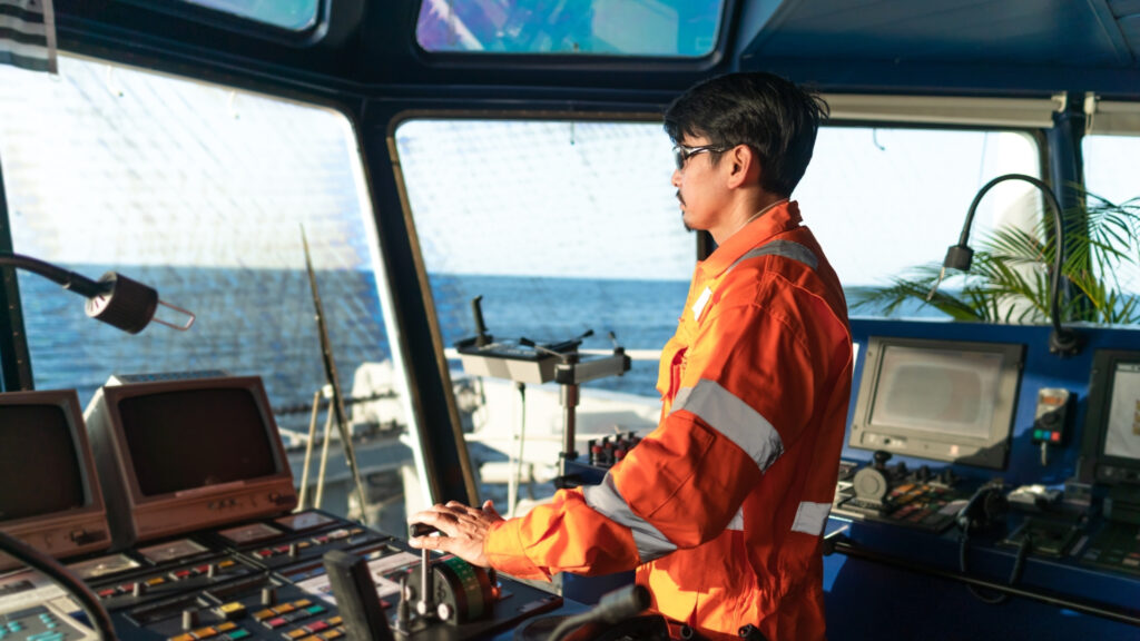 An officer at the bridge steering a ship into port
