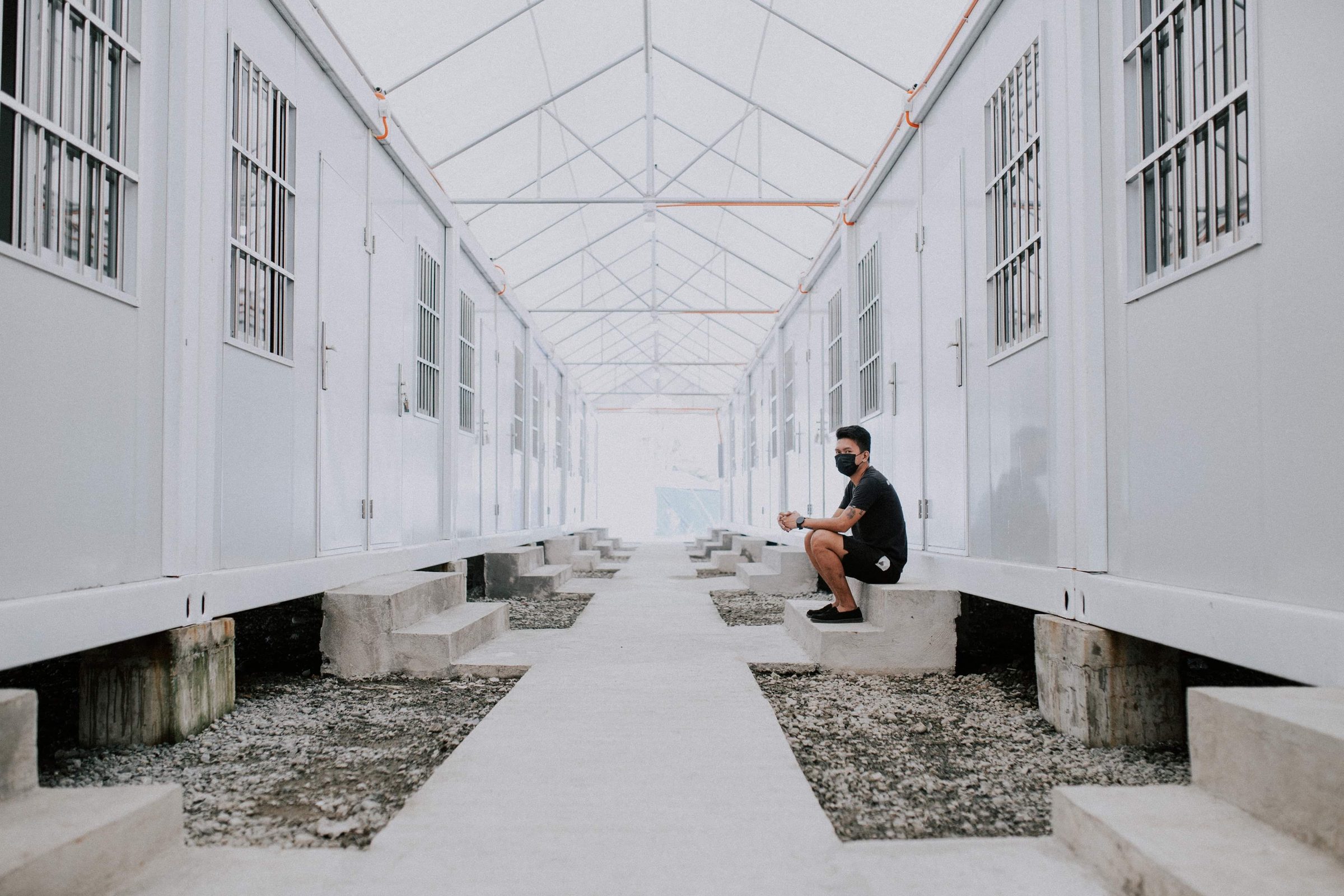A covered walkway running between rows of accommodation rooms