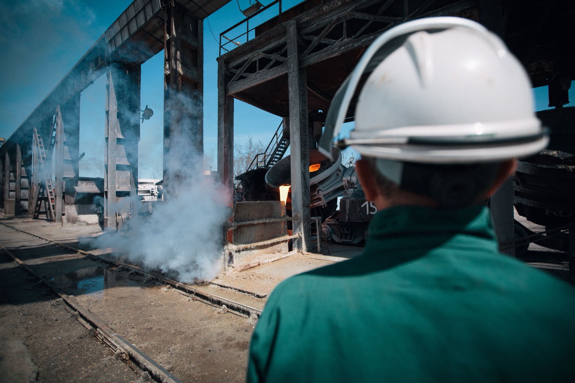 Worker beside steam piping